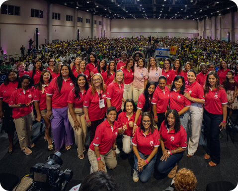 Grande evento com mulheres vestindo camisetas rosa, promovendo união e participação política com a mensagem 'faça parte'.