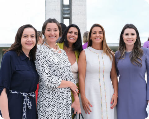 Deputada Roberta Roma posando ao lado de colegas em frente ao Congresso Nacional, representando o compromisso com uma política descomplicada e acessível.